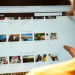 Woman exploring Lightroom tutorials on computer screen, perfect for online education themes.